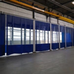 Kurtyny niebieskie z folią przezroczystą pcv 1mm na hali przemysłowej